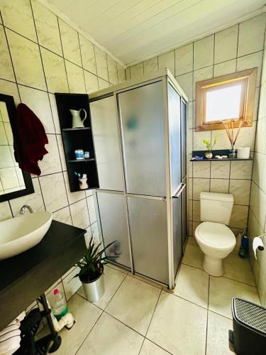 ein Badezimmer mit Dusche, Toilette und Waschbecken in der Unterkunft Cantinho aconchegante na Serra in Três Coroas