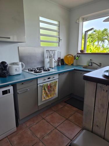 a kitchen with a stove top oven next to a window at Bel appartement avec piscine privée et vue exceptionnelle in Gourbeyre