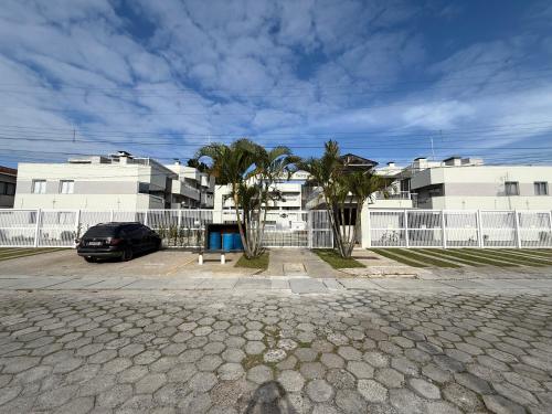 a car parked in a parking lot in front of buildings at Apartamento aconchegante in Matinhos