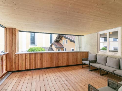 a large deck with a couch and a large window at Hopfgarten Alpin Living Top 3 und 4 in Hopfgarten im Brixental