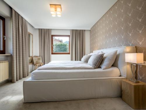 a bedroom with a large bed and a window at Luxury Central Kirchberg in Kirchberg in Tirol