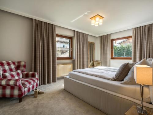 a bedroom with a bed and a chair at Luxury Central Kirchberg in Kirchberg in Tirol