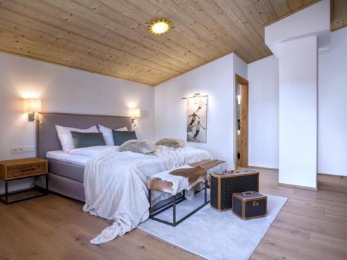 a bedroom with a large bed and a wooden ceiling at Luxury Central Kirchberg in Kirchberg in Tirol