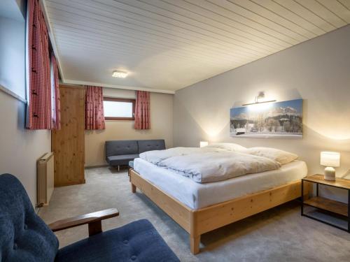 a bedroom with a large bed and a couch at Luxury Central Kirchberg in Kirchberg in Tirol
