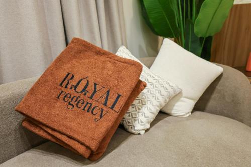 a brown blanket sitting on a couch with pillows at Royal Regency Hotel in Cairo