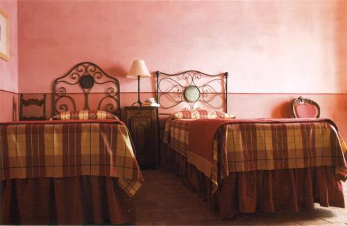 a bedroom with two beds and a table with a lamp at L'Atelier di Pierflavio Gallina in La Morra