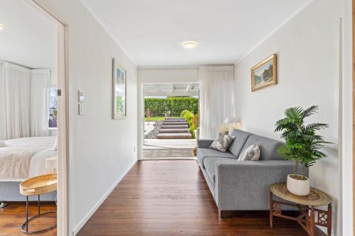a living room with a couch and a bed at Maraetai Beach Villa in Maraetai