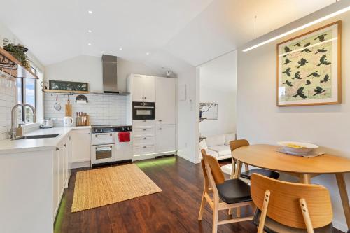 a kitchen and dining room with a table and chairs at Maraetai Beach Villa in Maraetai
