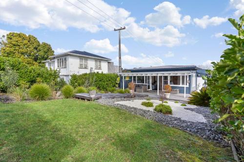 a house with a garden in front of it at Maraetai Beach Villa in Maraetai