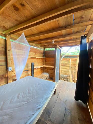 a room with a bed in a wooden cabin at Omnia puerto escondido in Malucano