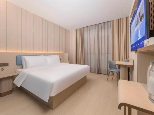 a hotel room with a white bed and a television at Hanting Huangshan Scenic Area South Gate Xiaoyaoxi Transfer Center in Huangshan