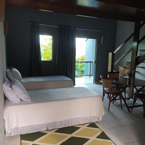 a bedroom with a bed and a desk and a window at Ariticum Chalés in Lagoa Sêca