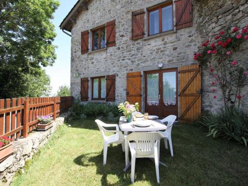 a table and chairs in front of a house at Gîte familial au calme avec jeux, VTT, randonnée, près du Parc Livradois, La Chaise-Dieu et Craponne - FR-1-582-214 in Jullianges