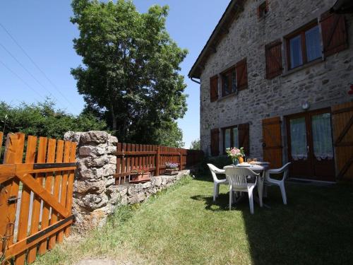 a patio with a table and chairs next to a building at Gîte familial au calme avec jeux, VTT, randonnée, près du Parc Livradois, La Chaise-Dieu et Craponne - FR-1-582-214 in Jullianges