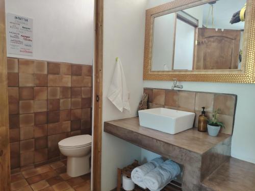 a bathroom with a sink and a toilet and a mirror at Nativa Beach Front in Sipacate
