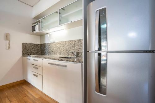 a kitchen with white cabinets and a refrigerator at Complejo Quartier San Telmo & Spa in Buenos Aires