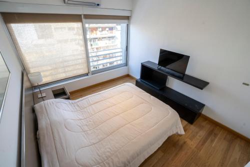 a small bedroom with a bed and a window at Complejo Quartier San Telmo & Spa in Buenos Aires