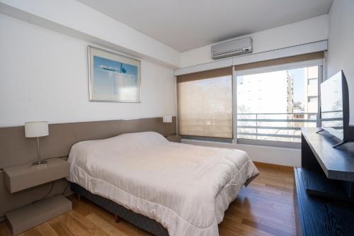 a bedroom with a bed and a large window at Complejo Quartier San Telmo & Spa in Buenos Aires