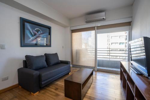 a living room with a couch and a tv at Complejo Quartier San Telmo & Spa in Buenos Aires