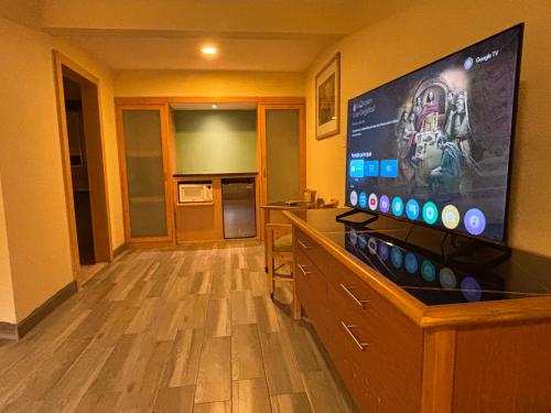 シウダー・フアレスにあるホテル コロニアル シウダッド フアレスの壁に大型の薄型テレビが取り付けられた部屋