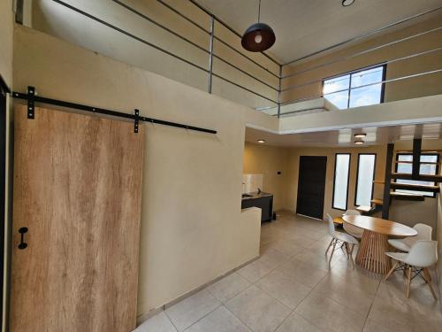 a room with a wooden door and a table and chairs at Loft Sp in San Pedro