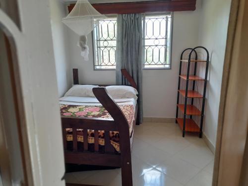 a small room with a bed and a window at Maasai Villa Backpackers Home in Fort Portal