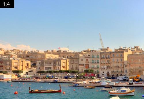 a group of boats in a harbor with buildings at Senglea Apartments in Senglea