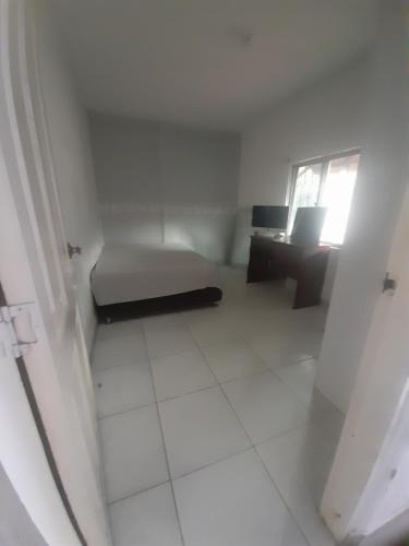 a small white room with a bed and a desk at Rey SALOMÓN SALJA in Barranquilla