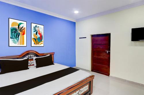 Un dormitorio con una cama y una pared azul. en Hotel O Classic luxury Rooms, en Warangal