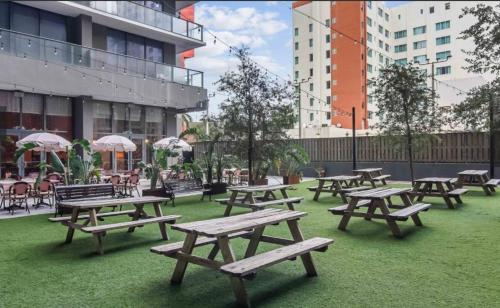a group of picnic tables on the grass with buildings at Downtown Miami Luxury Condo apartment in Miami