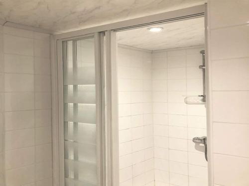 a shower with a glass door in a bathroom at 1-bedroom apartment with view of private beach in Agon Coutainville