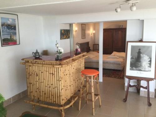 a bedroom with a bed and a bar with a stool at 1-bedroom apartment with view of private beach in Agon Coutainville