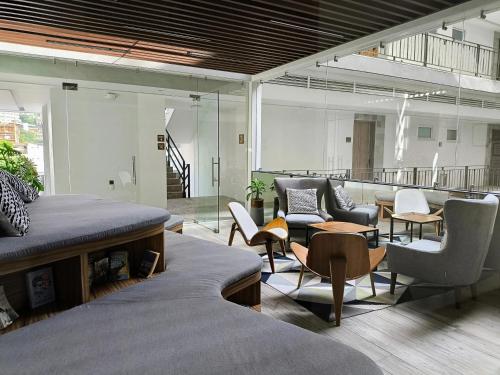 Una sala de estar con sofás, sillas y mesas. en Avida Residences Confort, en Puerto Vallarta