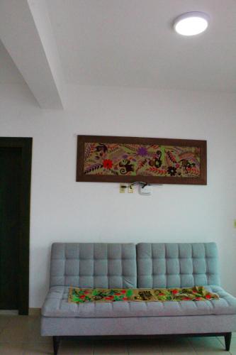 a couch in a living room with a picture on the wall at Hotel Monkey House Tuxtla Gutiérrez in Tuxtla Gutiérrez