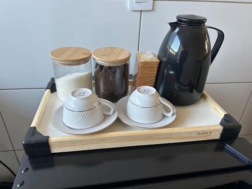 a tray with three cups and a vase on it at Casa 02 - Casa com 2 quartos, próximo a rodoviária e aeroporto in Palmas