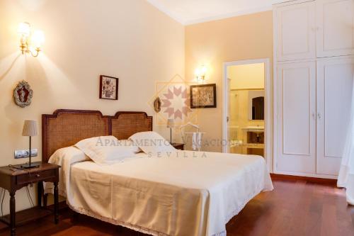 a bedroom with a bed with a white bedspread at Apartamento junto a la catedral in Seville