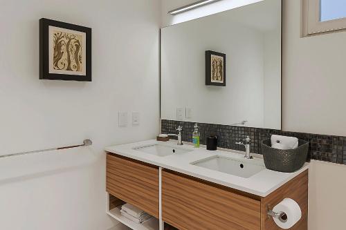 Un baño con lavabo y un espejo grande. en Avida Residences Confort, en Puerto Vallarta