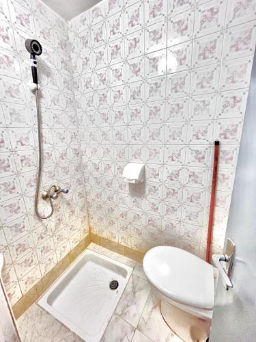a small bathroom with a toilet and a shower at Entire Surf & Beach Guest House in Taghazout in Taghazout