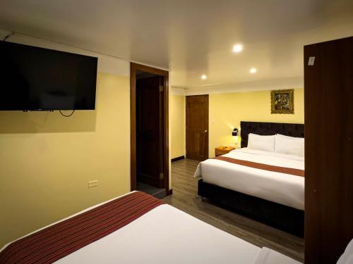 a hotel room with a bed and a flat screen tv at Santuario Machupicchu in Machu Picchu