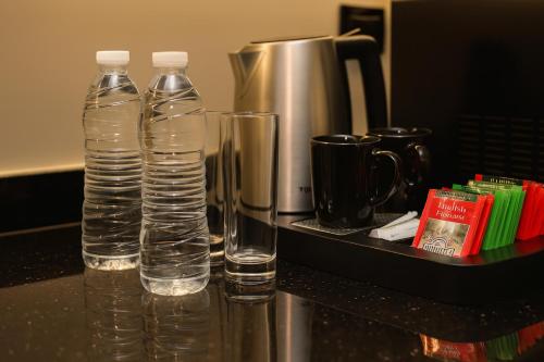 two bottles of water and two glasses on a counter at Royal Regency Hotel in Cairo