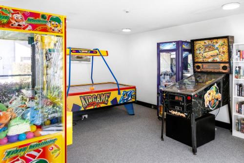a room with two arcade games and a claw machine at The Beach Retreat Coolum in Coolum Beach