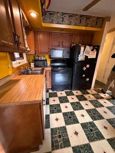 a kitchen with a black refrigerator and a checkered floor at Tekoa Duncan Apartments in Northfield
