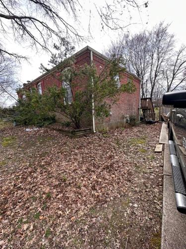 a red brick house with a tree in front of it at Tekoa Duncan Apartments in Northfield