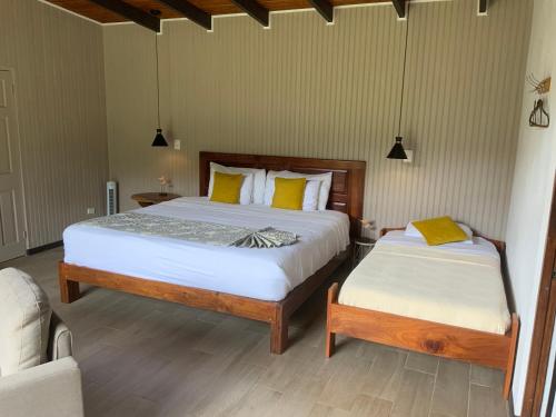 a bedroom with two beds and a couch at YerbaBuena Lodge in Monteverde Costa Rica