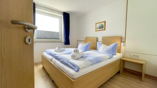 Un dormitorio con una cama con dos toallas encima. en Haus Horizont I HZ04, en Sahlenburg