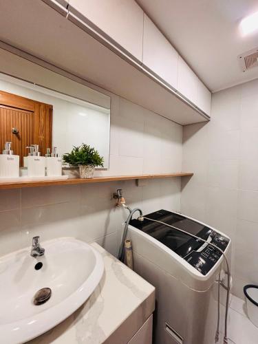 a bathroom with a sink and a washing machine at Relaxing Escape with Spacious Sofa Corner in Mandurriao