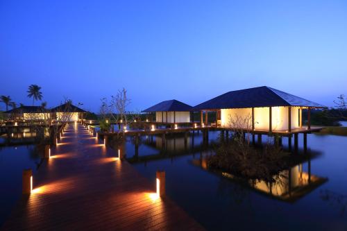 a resort with lights on the water at night at Anantaya Resort & Spa Chilaw in Chilaw