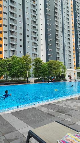 セパンにあるTRAVELLERS' ROOM JrMaster Near KLiA SiC at UmahSinggah NamTigaの高層ビルの前の大きなプール