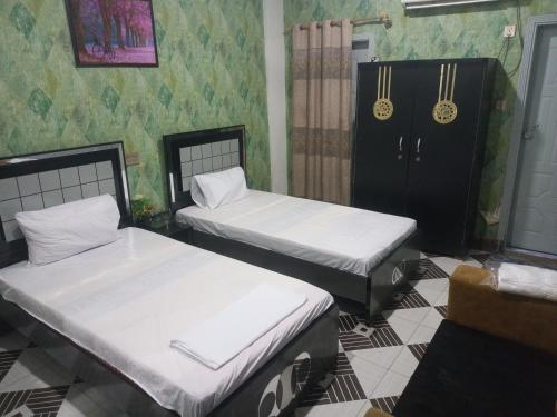two beds sitting in a room with green wallpaper at Sherton inn hotel in Hyderabad