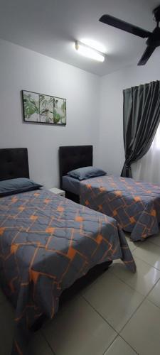 セパンにあるTRAVELLERS' ROOM JrMaster Near KLiA SiC at UmahSinggah NamTigaのベッド2台と天井ファン付きの寝室